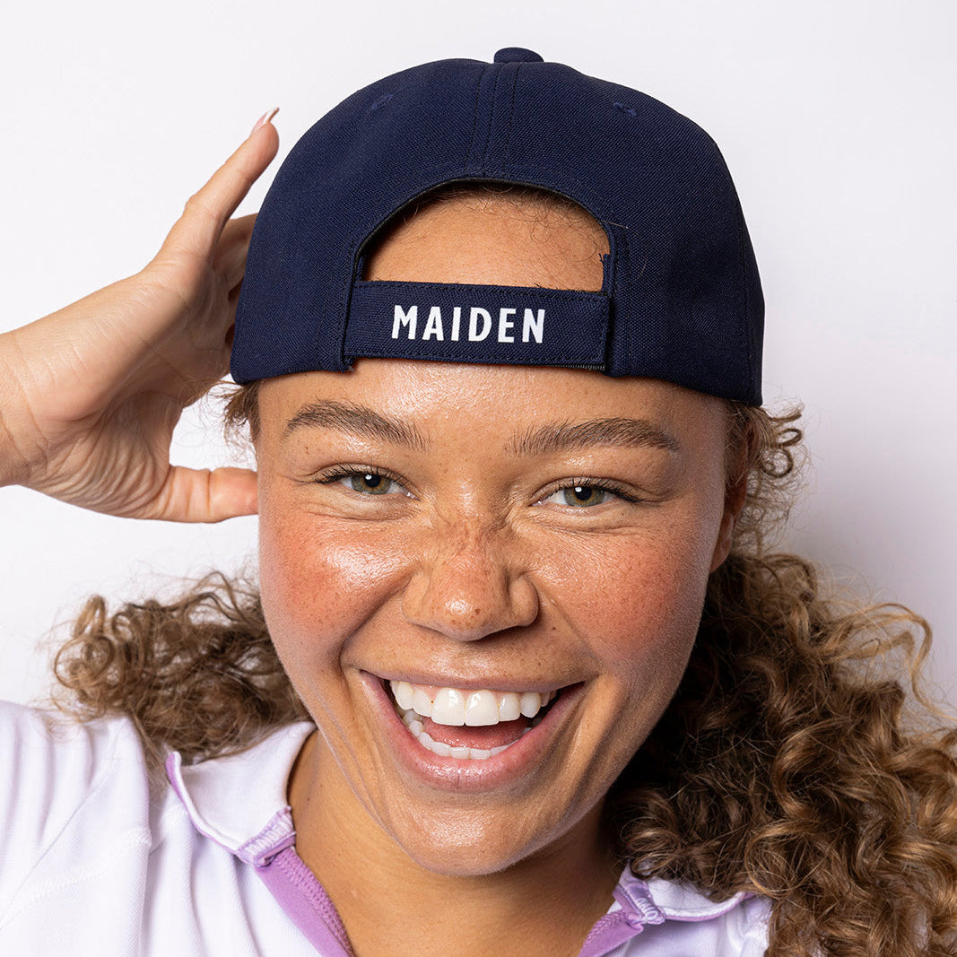 Person wearing a navy cap with 'MAIDEN' text on a white background