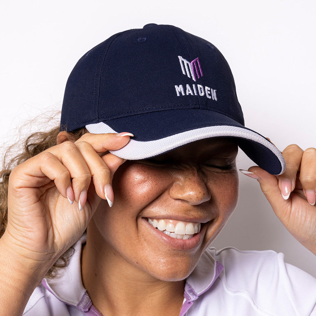 Person wearing a navy cap with 'MAIDEN' logo on a white background