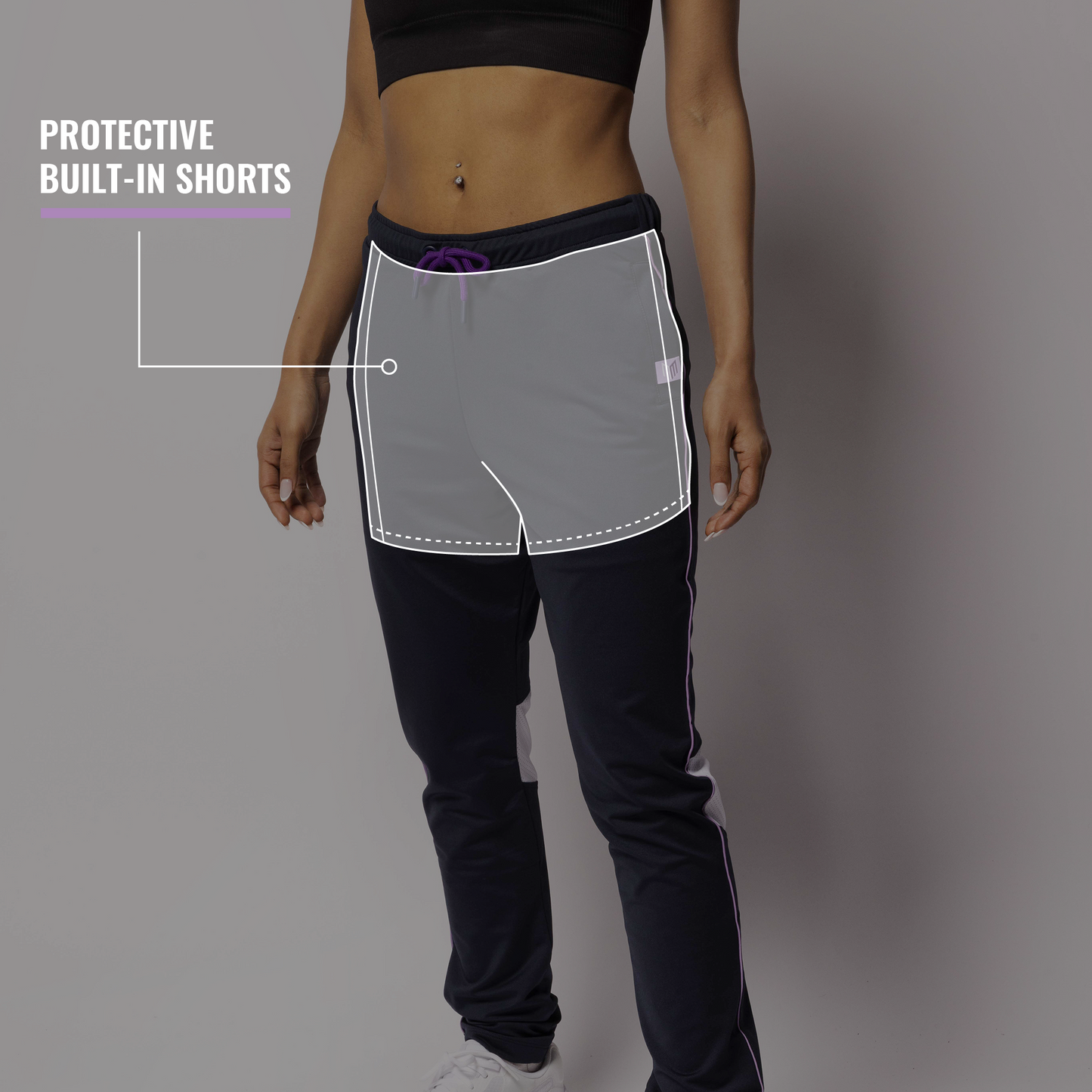 Person wearing a black sports bra and pants with built-in shorts on a gray background