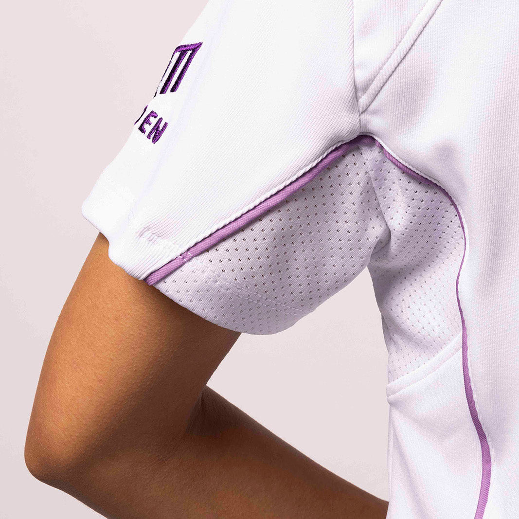 Close-up of a white sports jersey with purple accents on a plain background