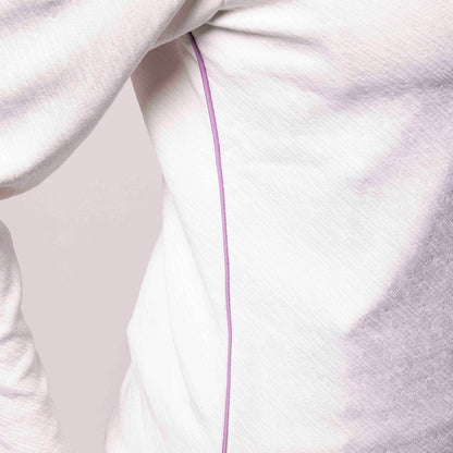 Close-up of a white garment with a purple line on a plain background