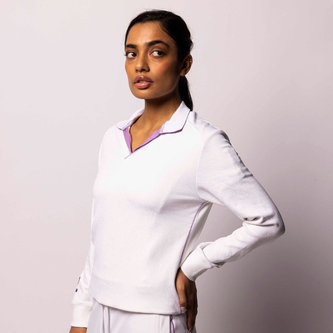 Woman wearing a white medical uniform against a plain background