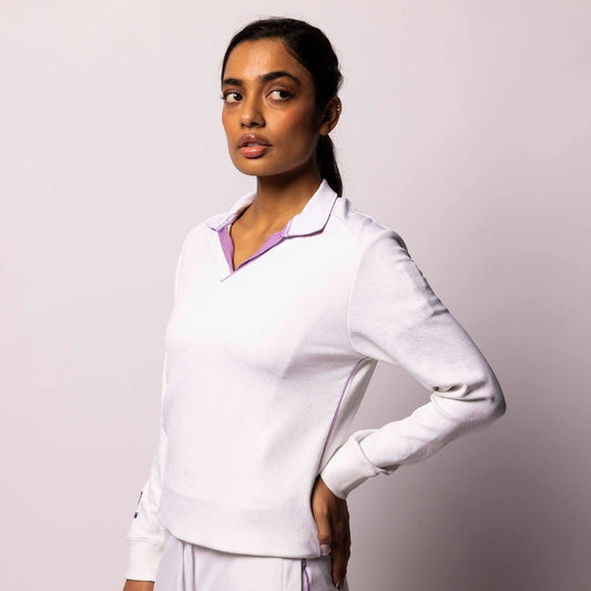 Woman wearing a white medical uniform against a plain background