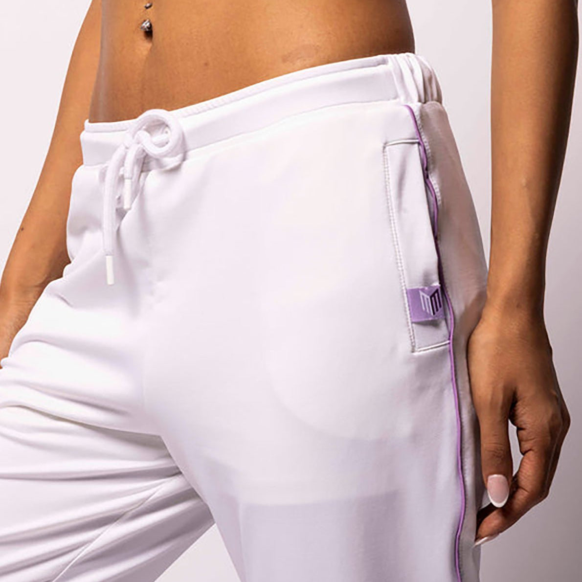 White jogger pants with purple accents on a plain background