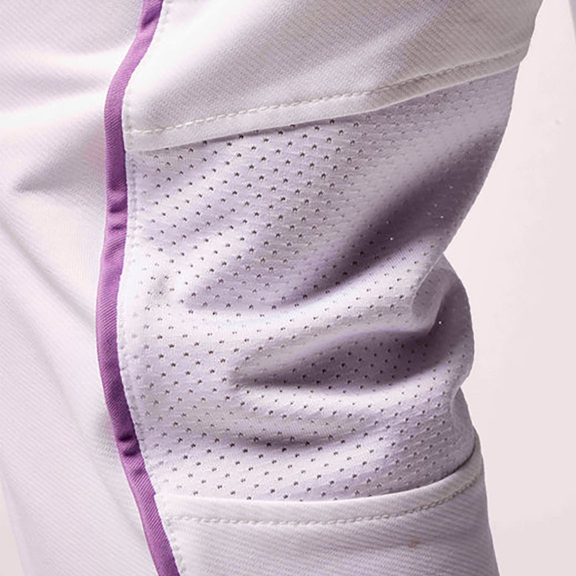 Close-up of a white athletic outfit with purple accents on a light gray background
