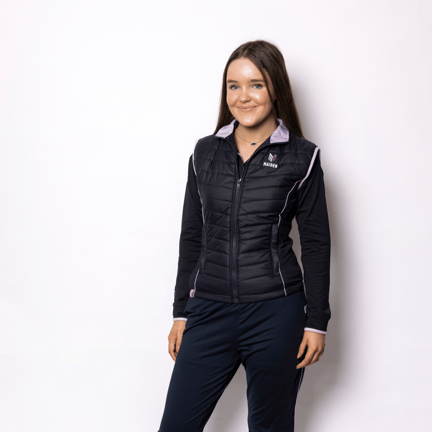 Woman wearing a black gilet and pants on a white background